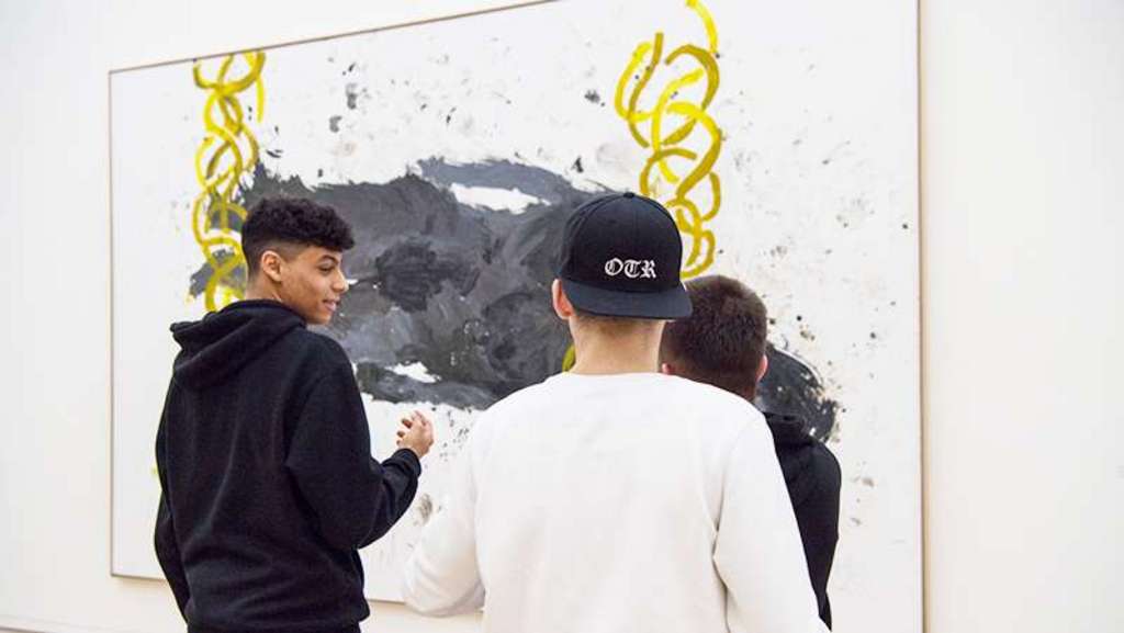 Zwei Jungs in schwarz und weiss vor einem abstrakten Gemälde.